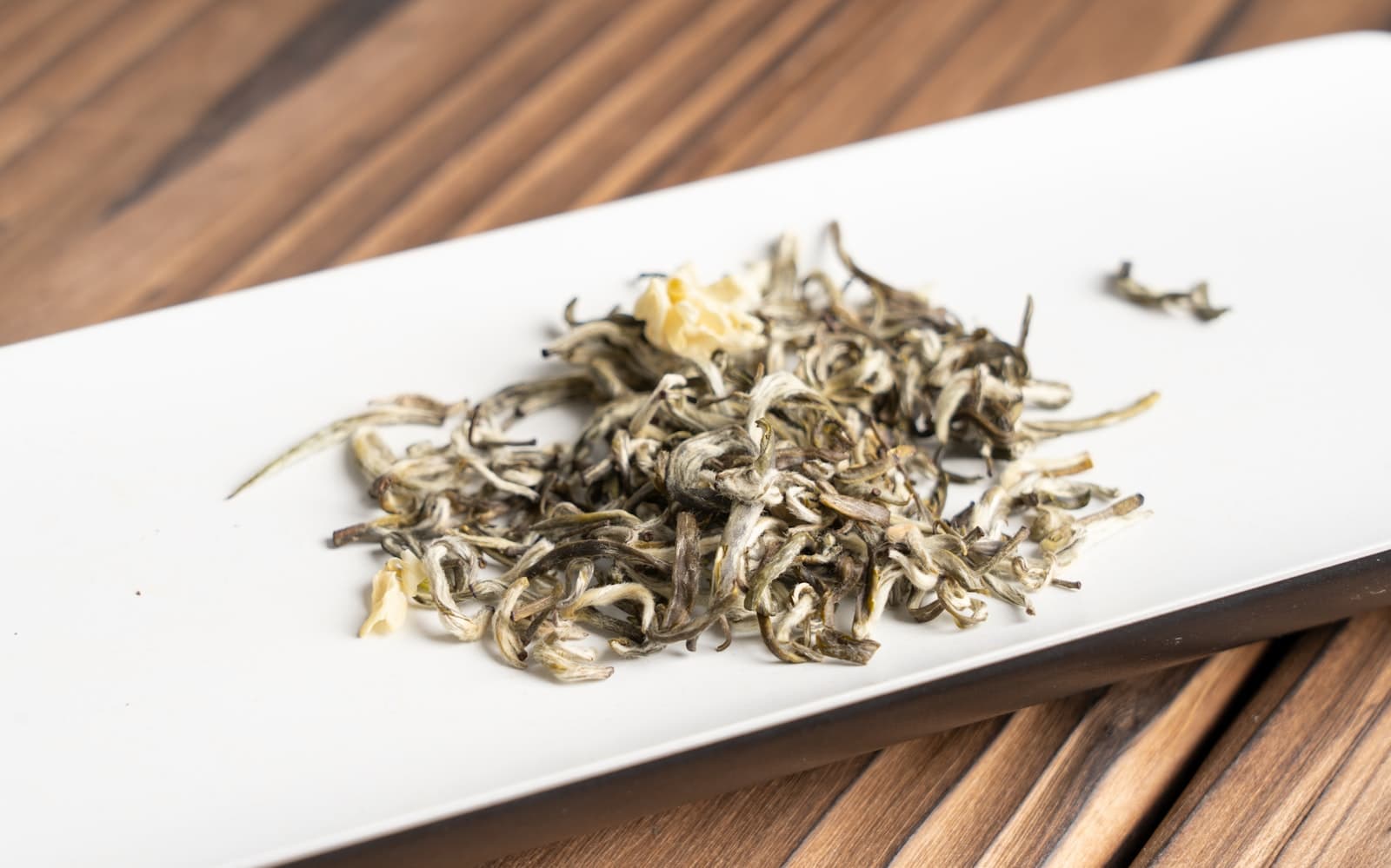 First-pick green tea tips with jasmine, drying on a plate